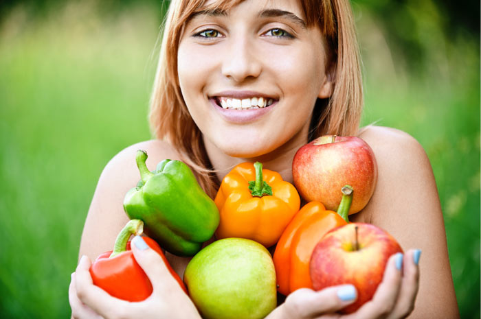 woman holding fruits and veggies